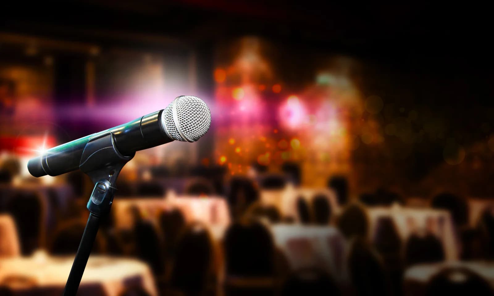 Presenter holding a wireless handheld microphone during a business event or conference session