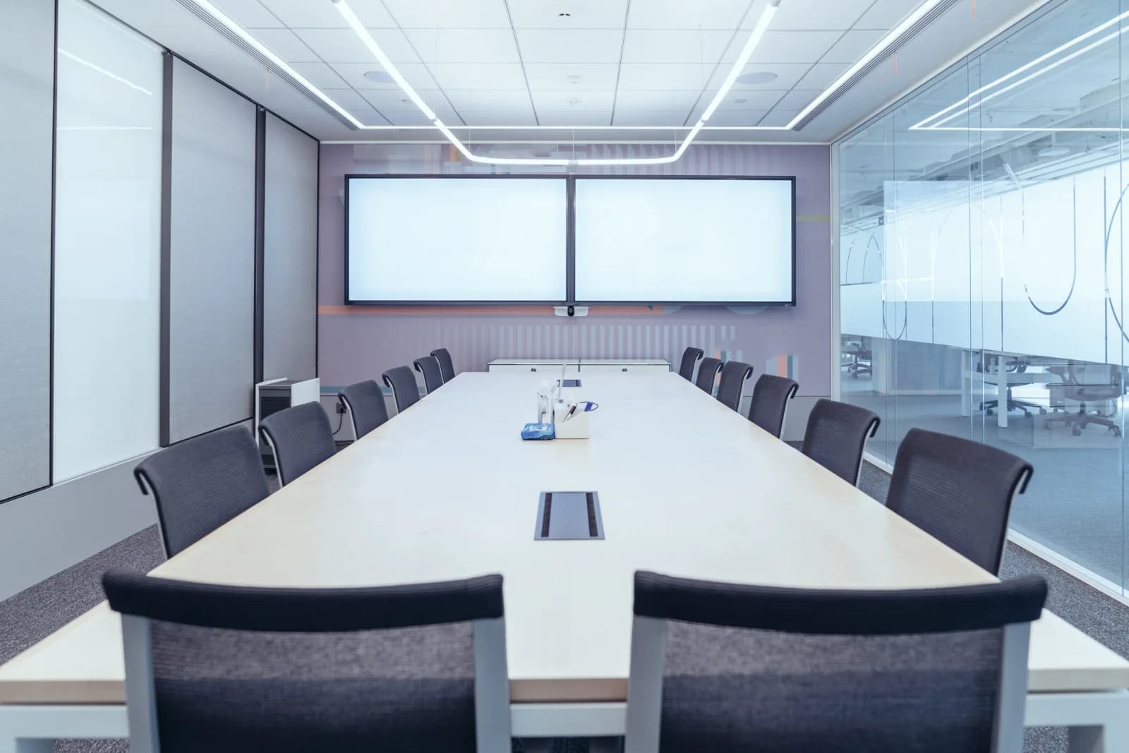 Standard HD television on a floor stand in a meeting room showing business presentation content