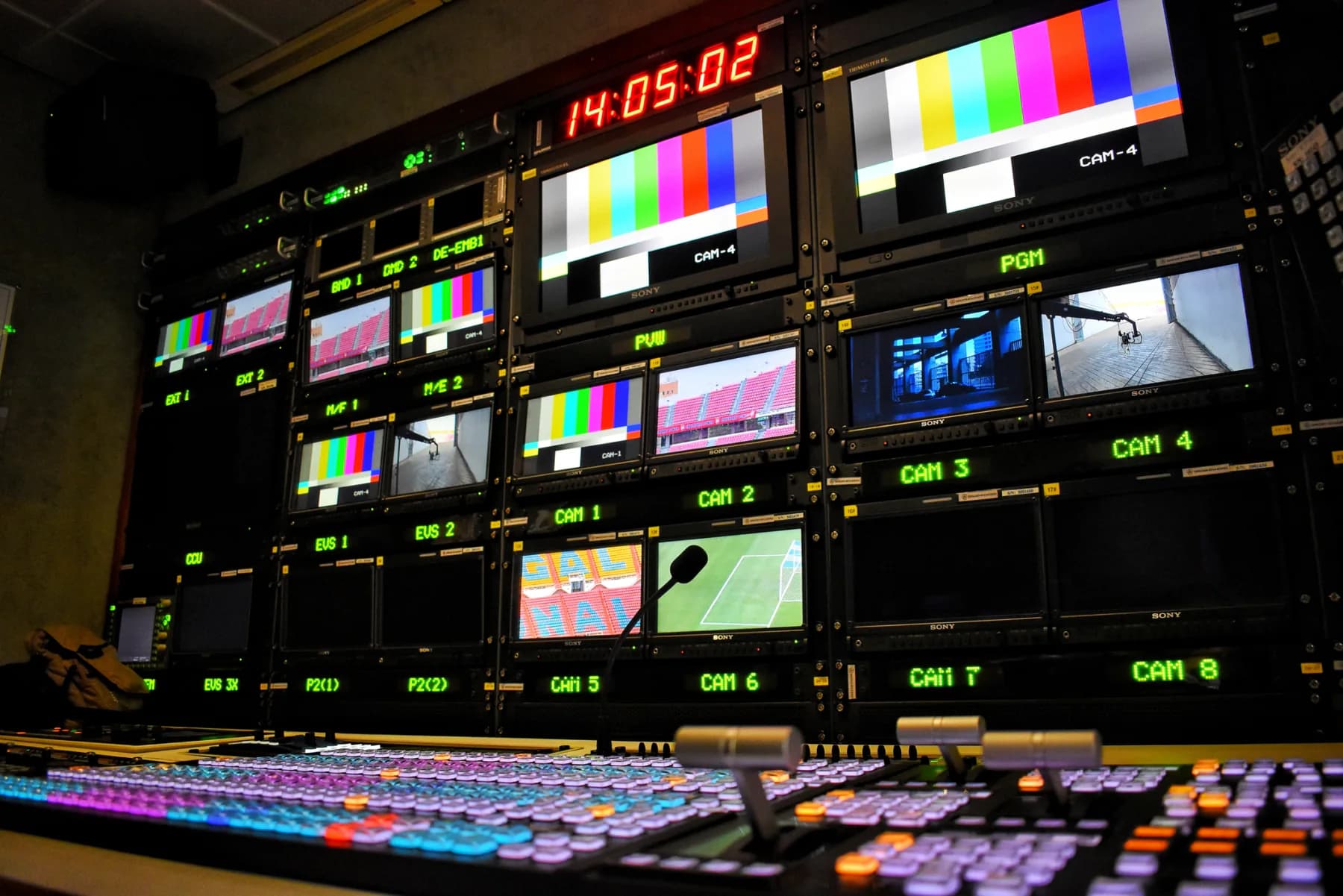 Sporting event operations environment with staff using laptops, tablets, support displays, and credentialing technology at a stadium or arena
