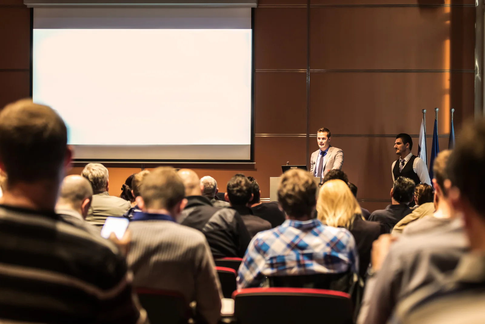 Projector on a cart in a meeting room projecting a business presentation onto a screen