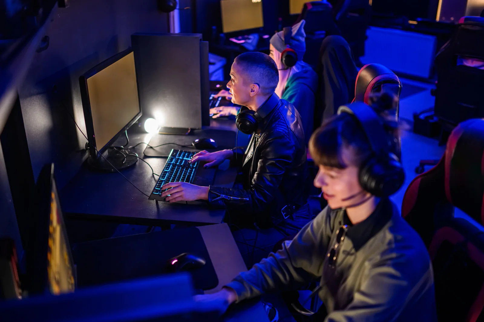 Gaming monitors on tables with peripherals for tournament stations and performance event setups