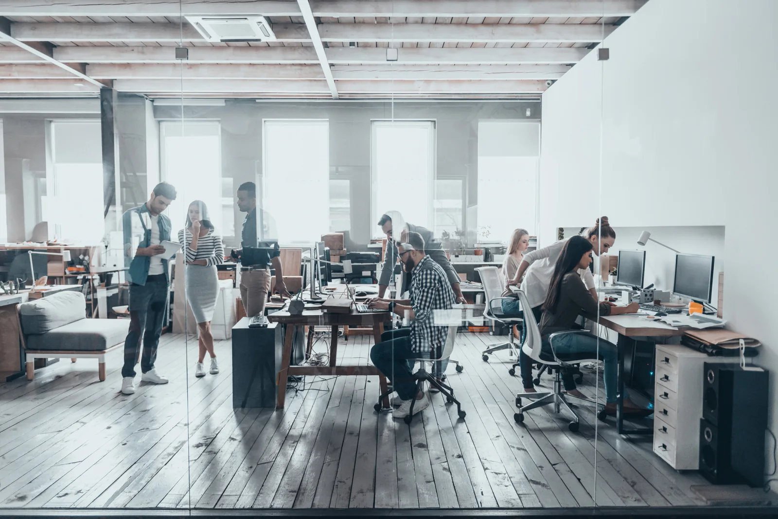 Swing space office during renovation with rental computers, monitors, printers, and employees working from a temporary office environment