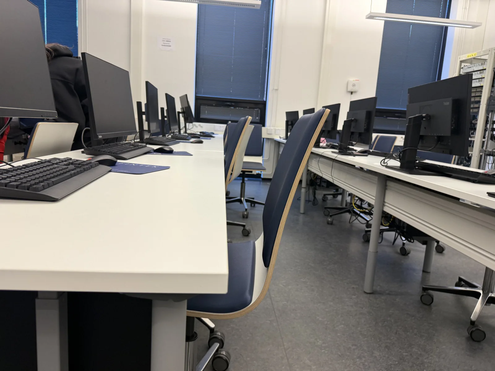 Proctored testing center with standardized rental laptops, monitors, and exam lab workstations prepared for a scheduled test session