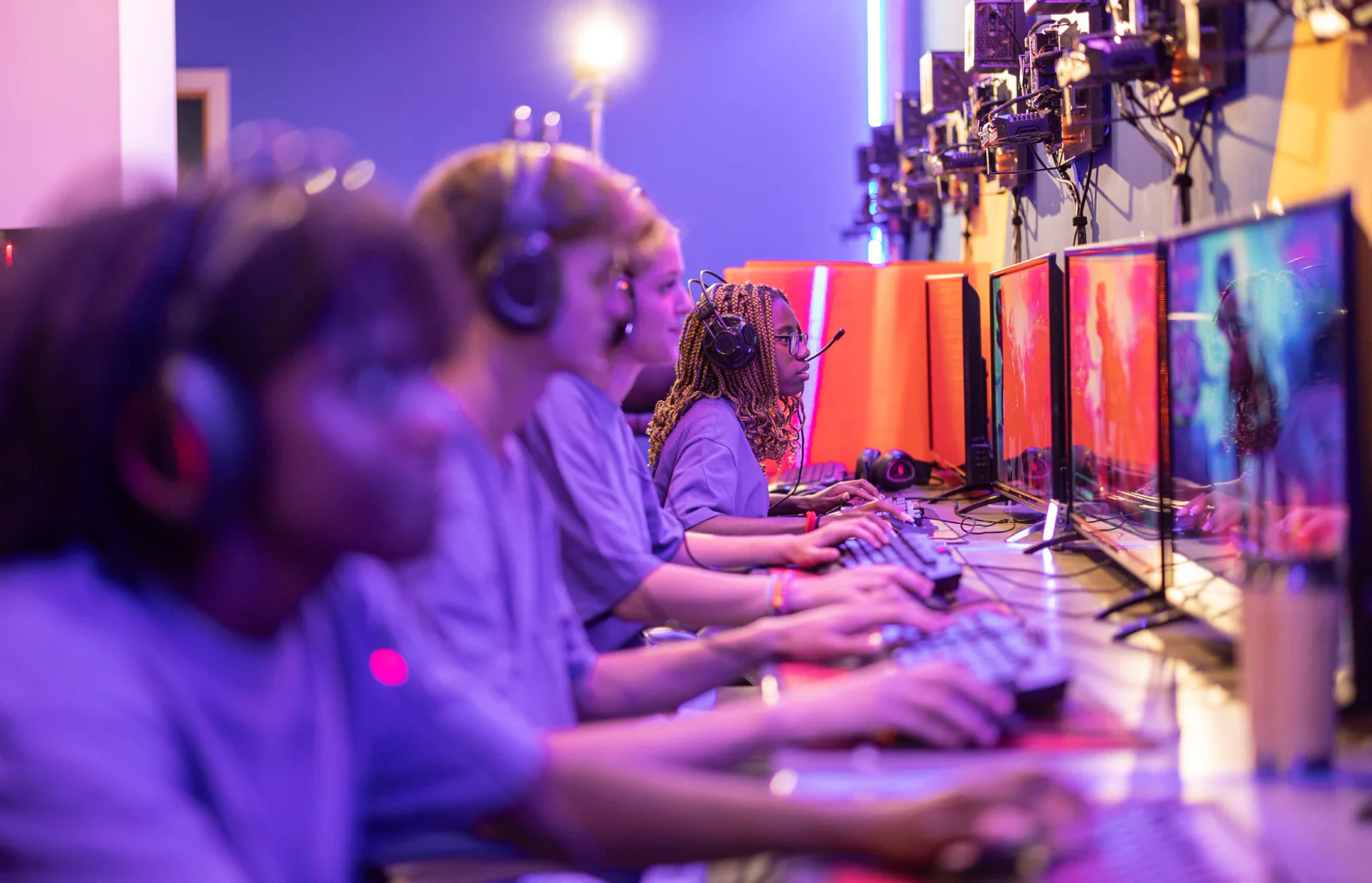 College esports event with students competing on gaming PCs in a campus venue with monitors and tournament staff
