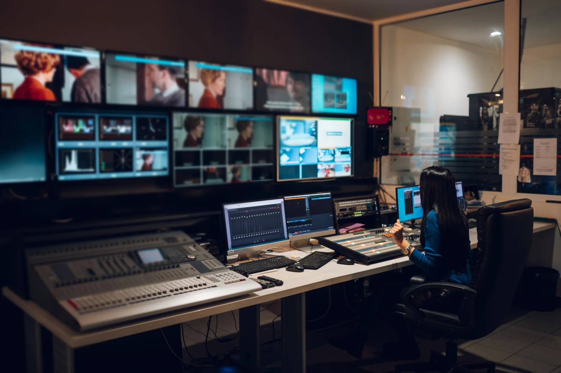 Broadcast control room with production workstations and multiple monitoring displays