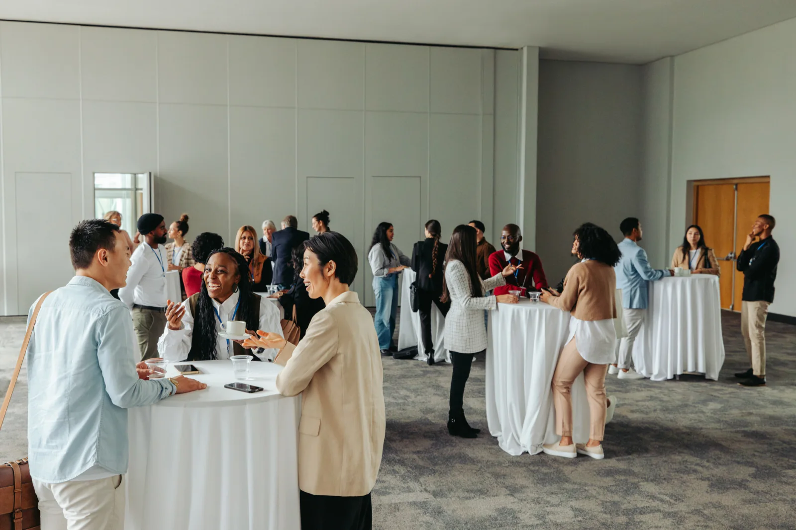 Convention center sponsor lounge with branded displays, digital kiosks, seating, and attendee engagement areas