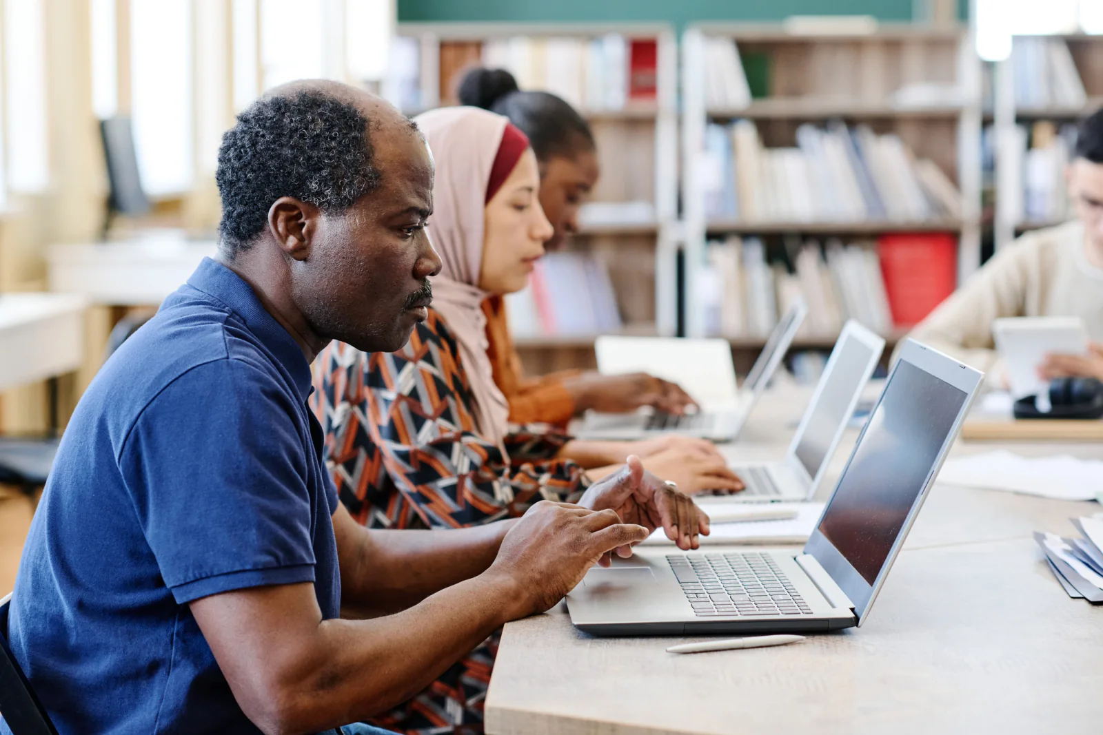 Students taking online assessments on identical laptops in a temporary school testing lab