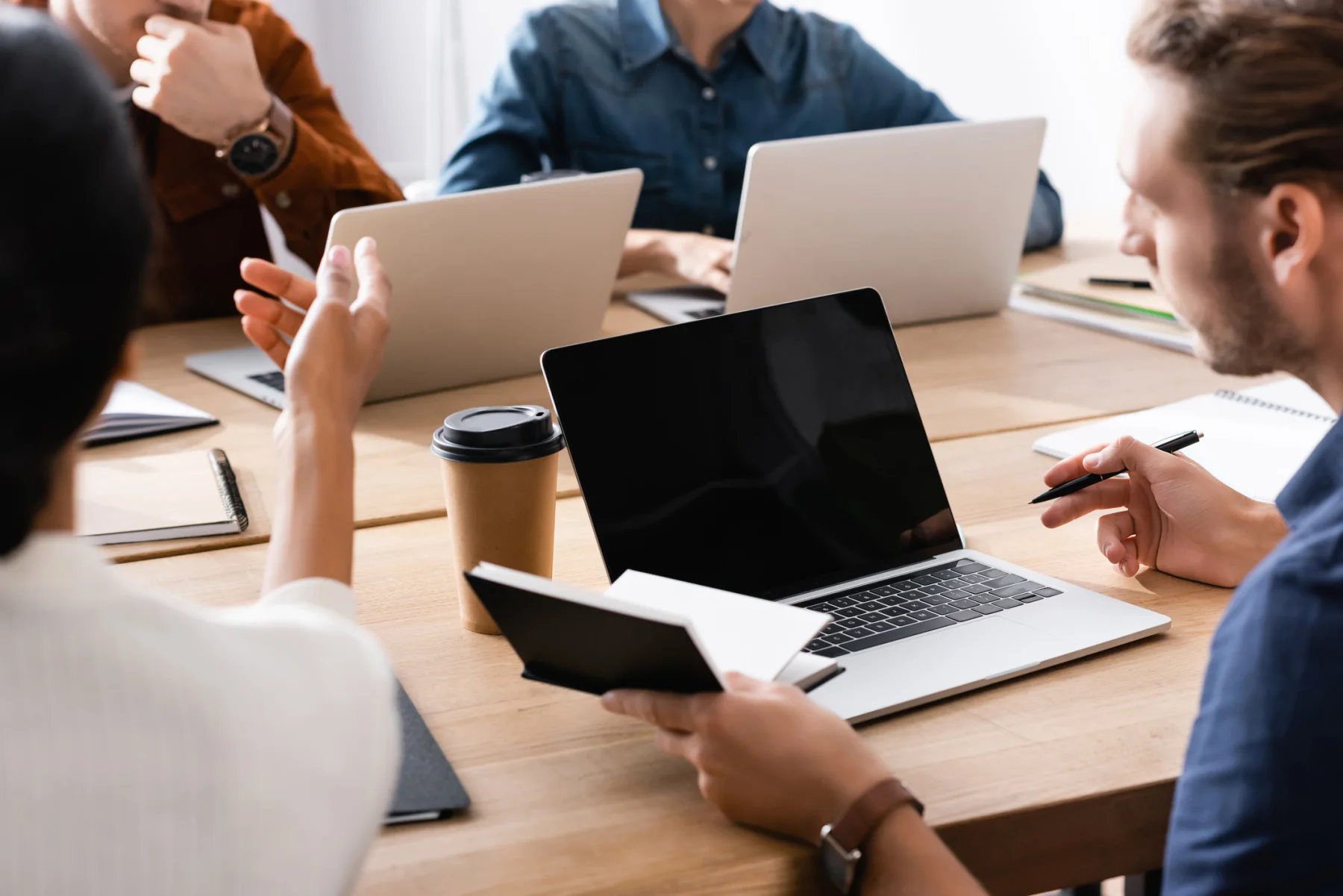 Enterprise team working in a modern office with laptops, monitors, and collaboration displays