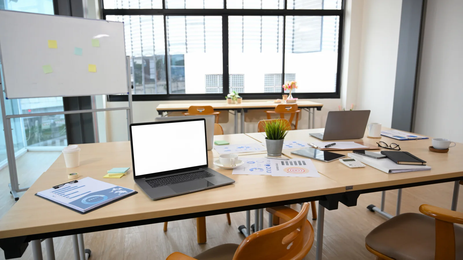 Stacks of laptops and monitors prepared for a large enterprise technology rollout across multiple locations