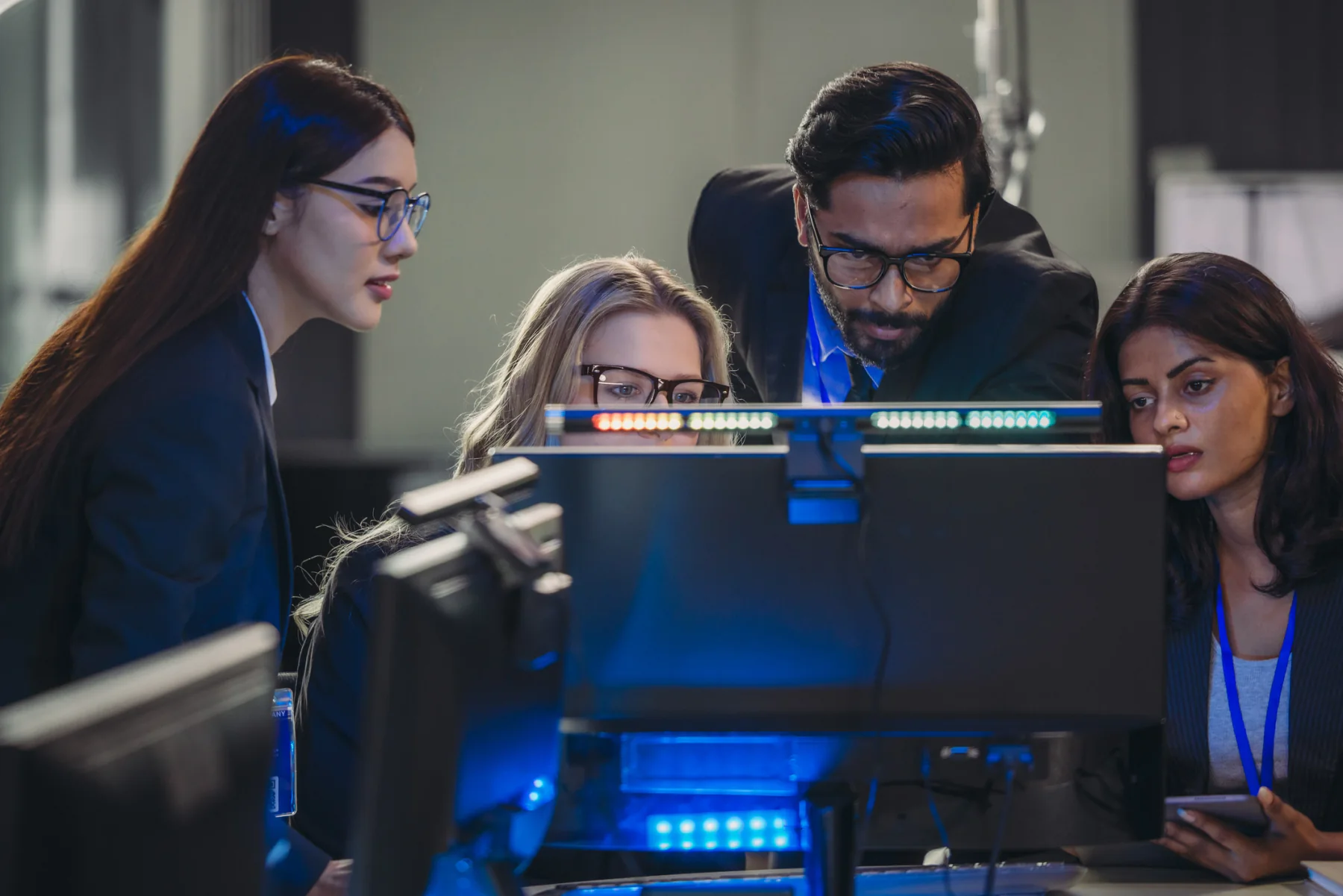 Financial services team working with laptops and dual monitors in a professional office