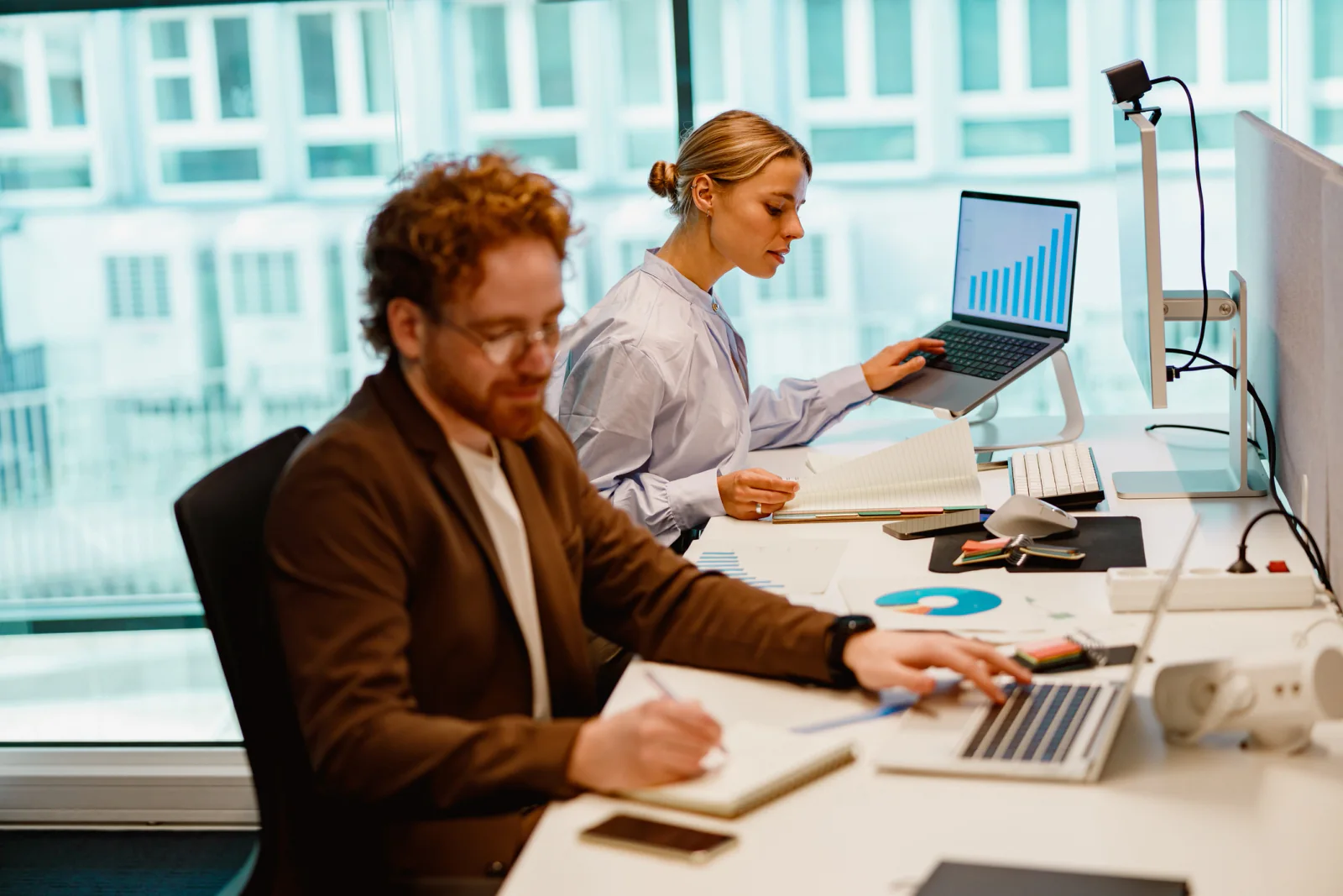 Audit professionals working on laptops and dual monitors in a temporary financial services war room