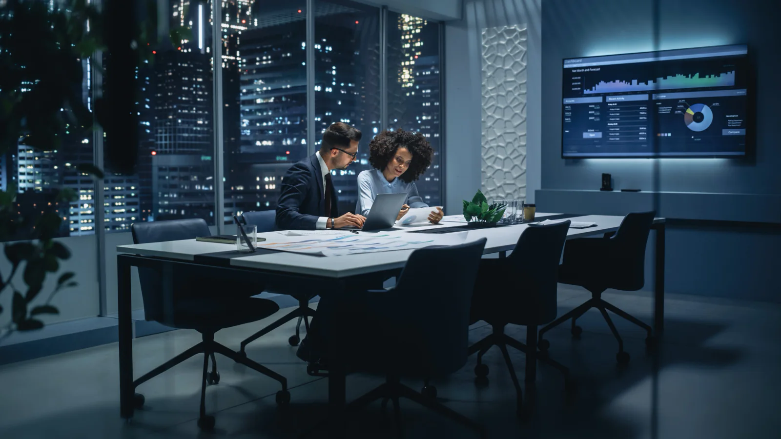 Executive board meeting and investor presentation setup with large displays, presentation laptops, and professional AV equipment