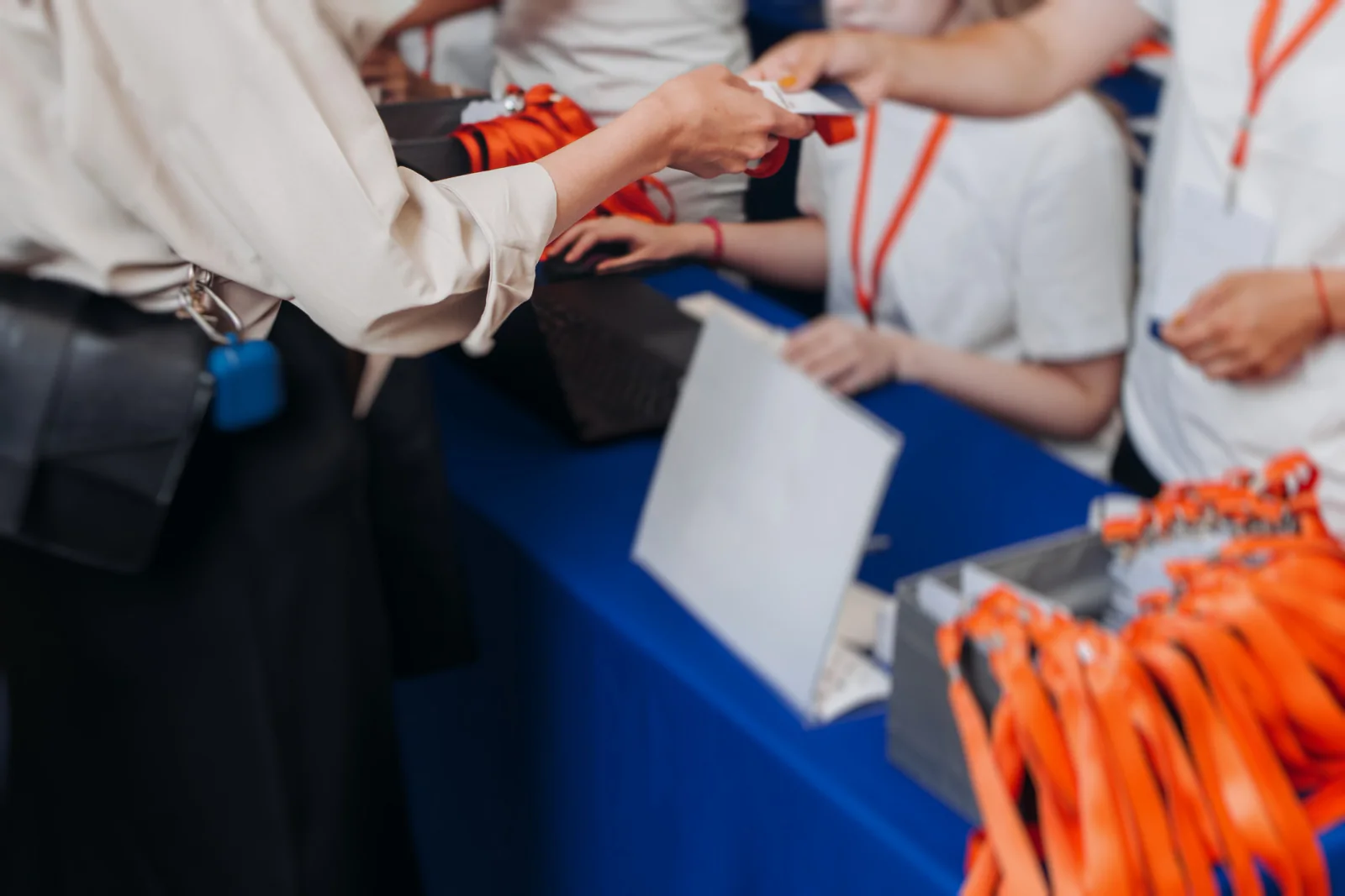 Government conference registration area with check-in laptops, digital signage, large displays, and attendees arriving at an expo venue