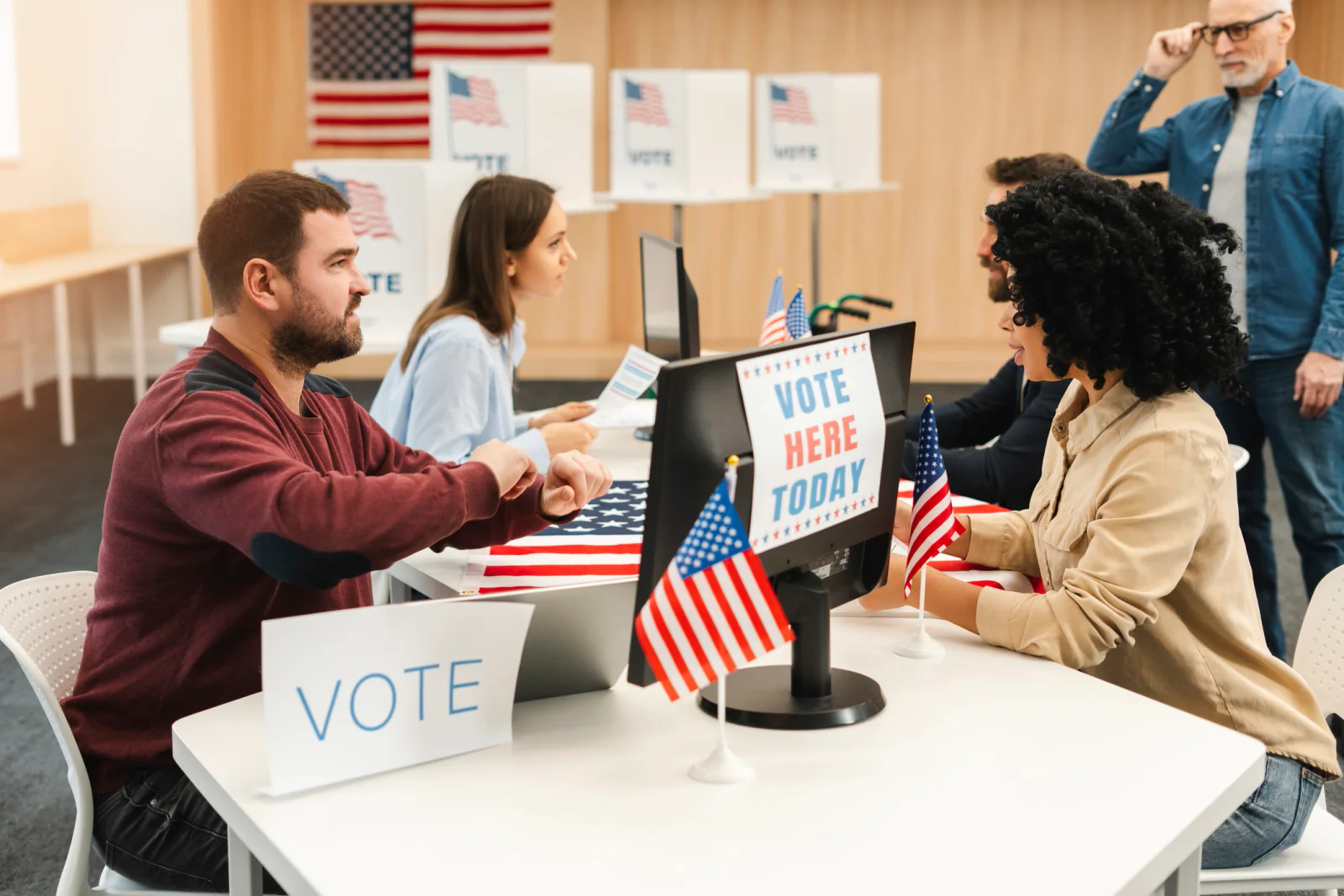 Election support and voter services area with laptops, tablets, printers, and information displays for public assistance staff