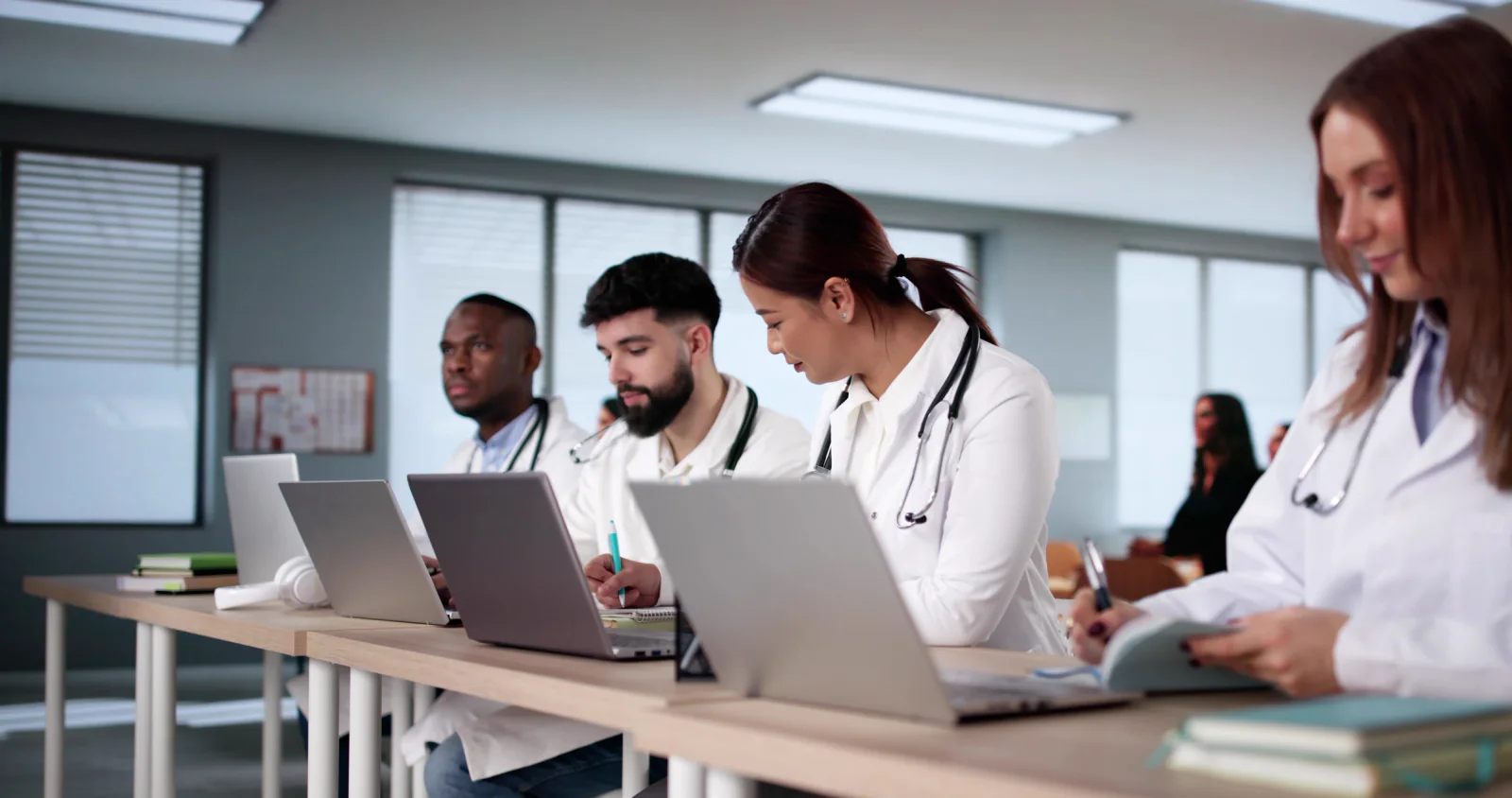 Temporary healthcare clinic with laptops and tablets at registration and exam areas during a patient surge