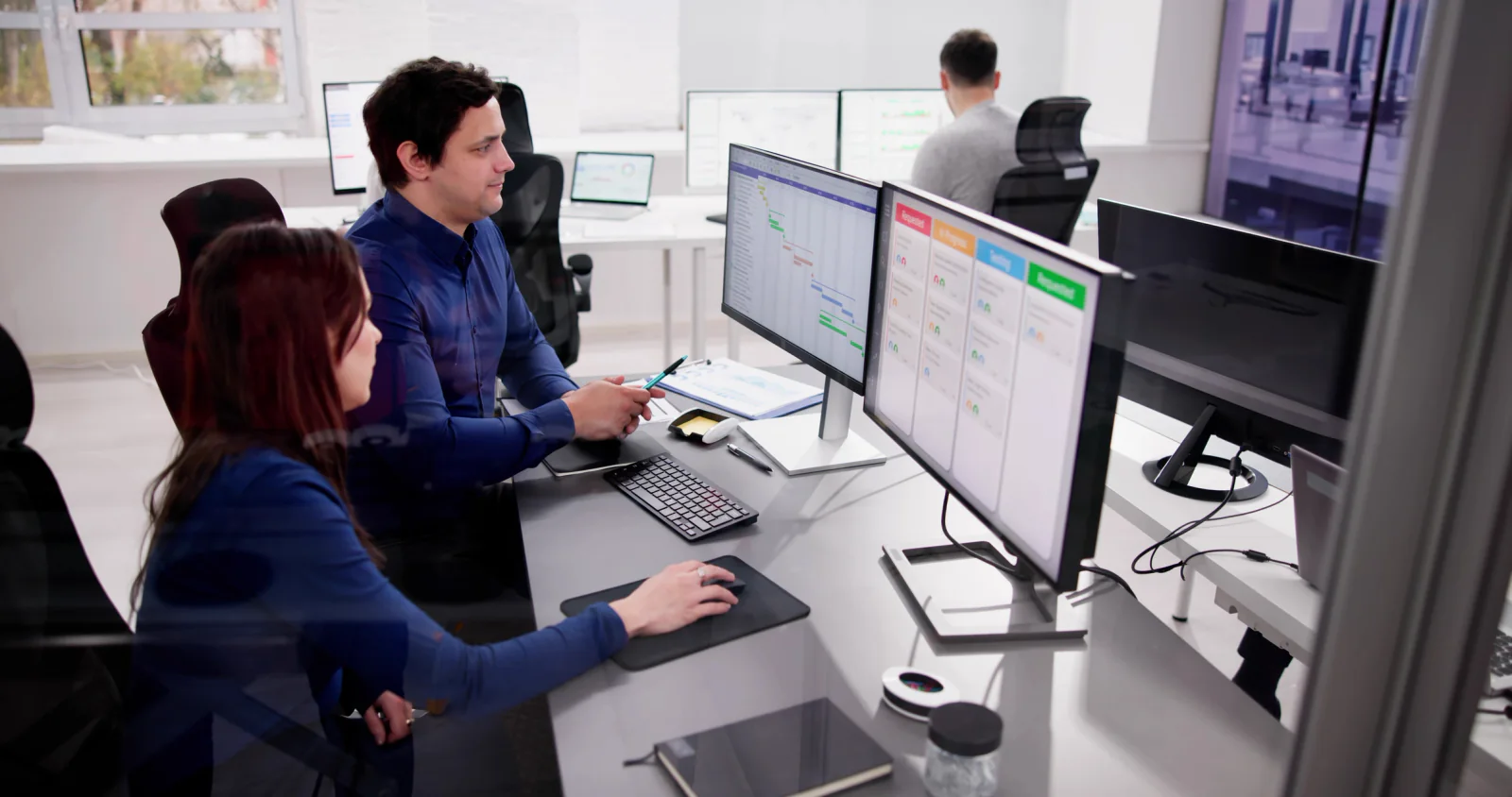 Temporary legal response center with compliance and legal teams working on secure laptops, monitors, and large dashboard displays