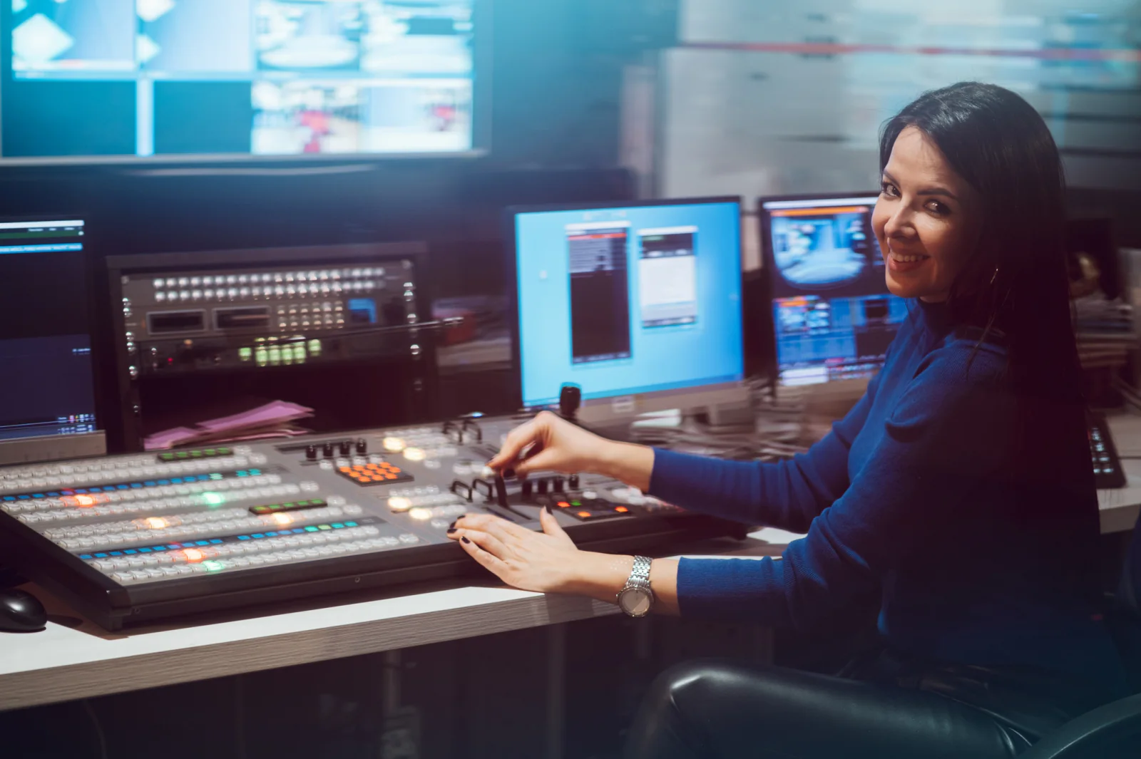 Control room with multiple monitors and staff managing a live stream production