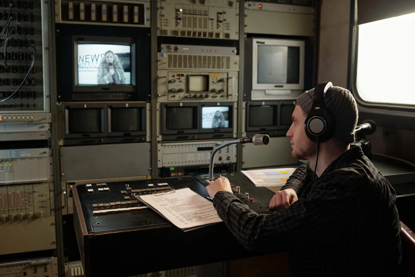 Film or content crew on location using laptops, field monitors, and networking gear to review footage and manage production