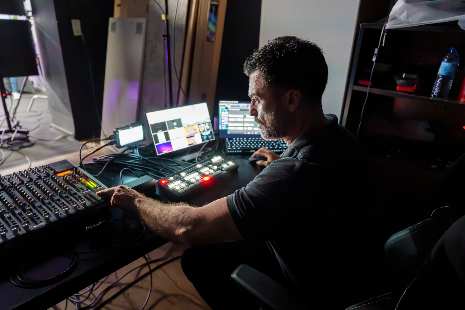 Post-production edit suite with dual monitors and a producer reviewing content