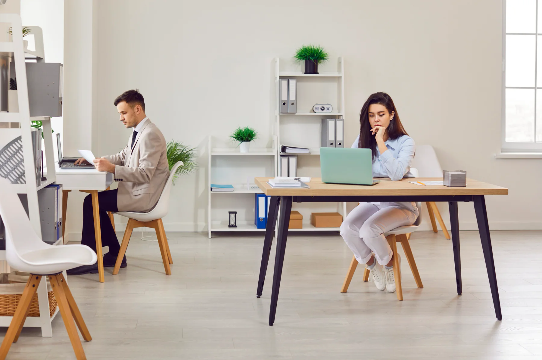 Small business team collaborating in a modern office with laptops and a large display