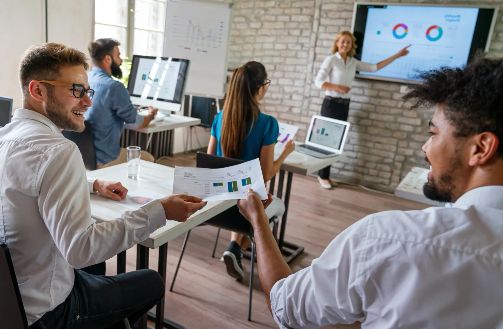 New employees in a training room using laptops during onboarding