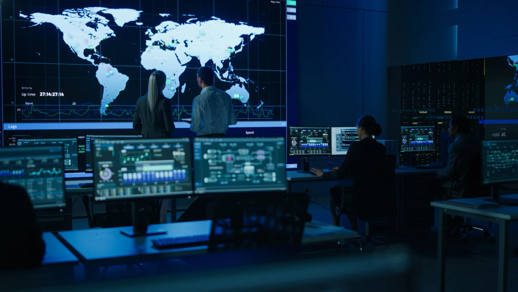 Telecommunications network operations center with staff monitoring multiple screens