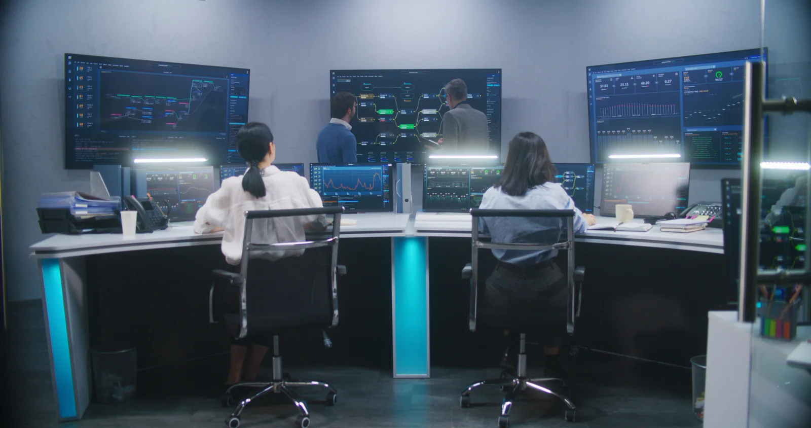 Marketing campaign war room with large dashboards multiple workstations and team members coordinating a product launch