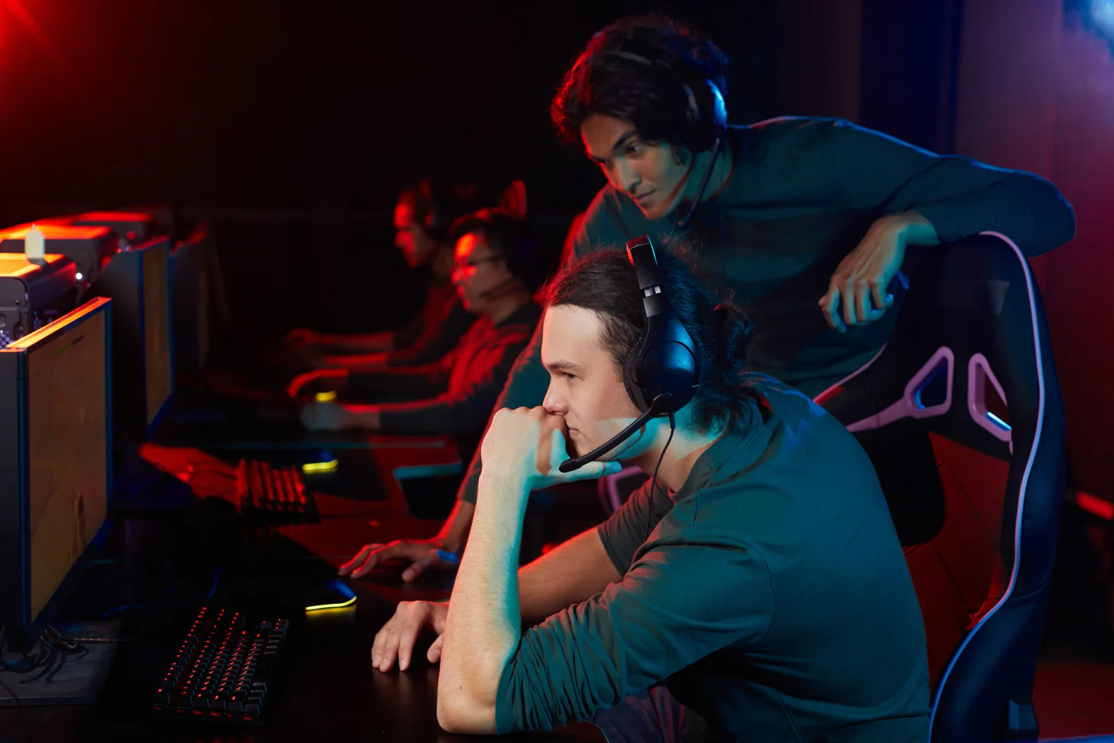 Esports team practicing together in a room full of gaming setups