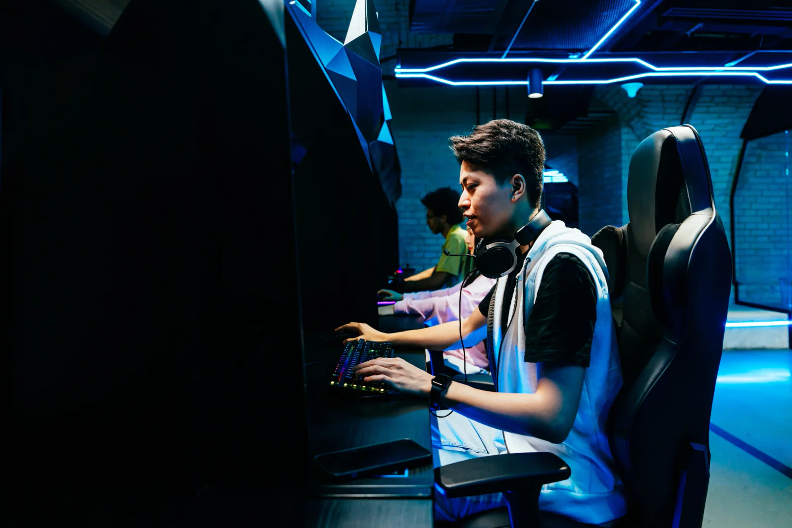 Esports stage with players at PCs and a large audience watching the match