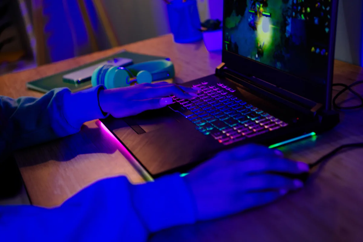 Esports tournament environment with players using gaming laptops at matched competition stations