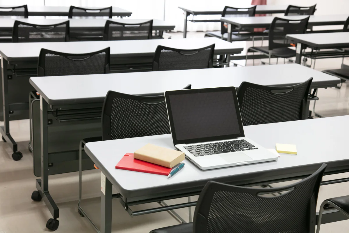 Students taking an online assessment on Chromebook laptops in a testing center environment