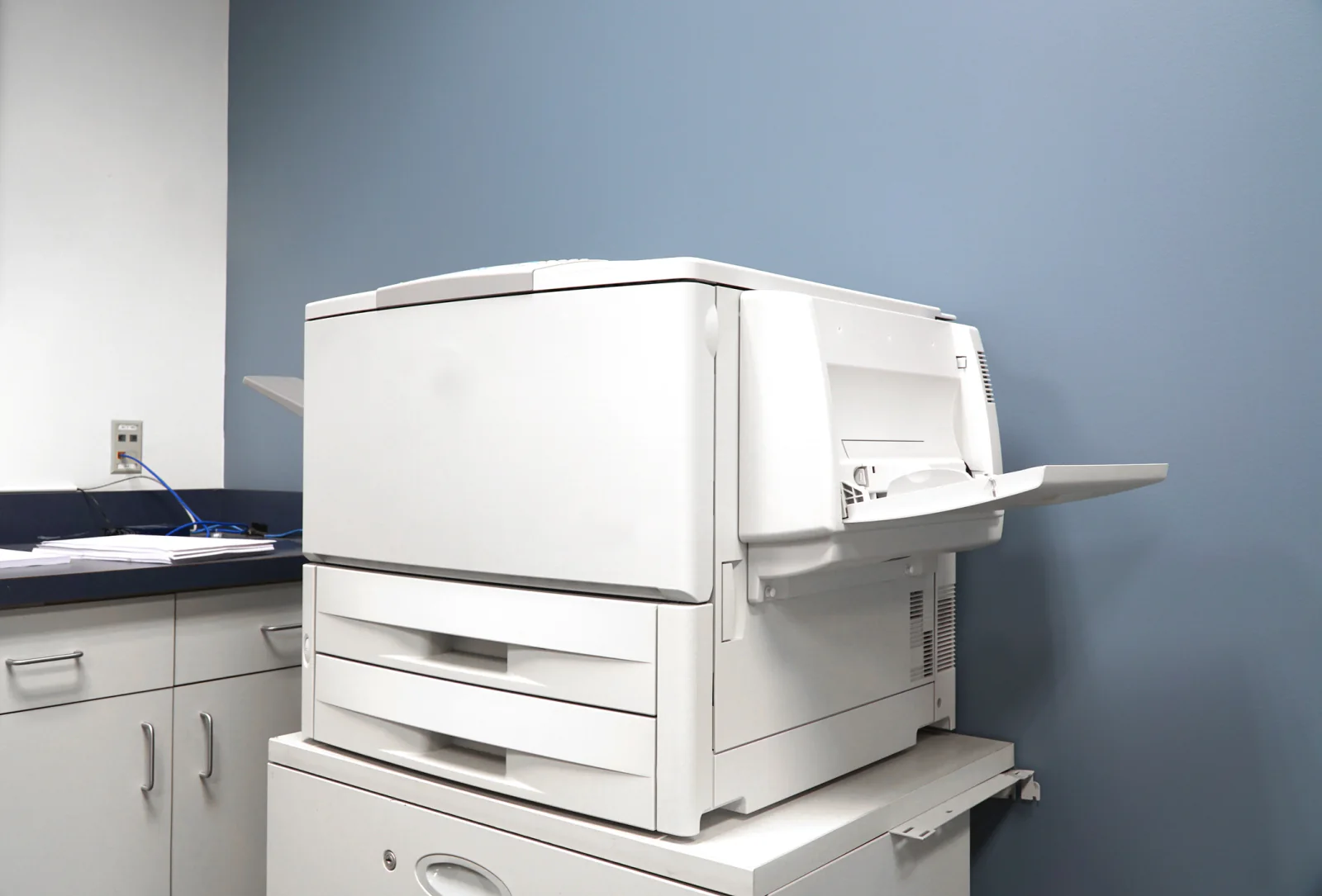 Monochrome laser printer on an office desk printing business documents for temporary office use