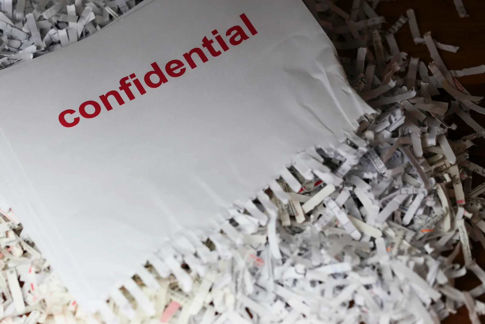 Compliance officer overseeing secure document shredding in an office environment