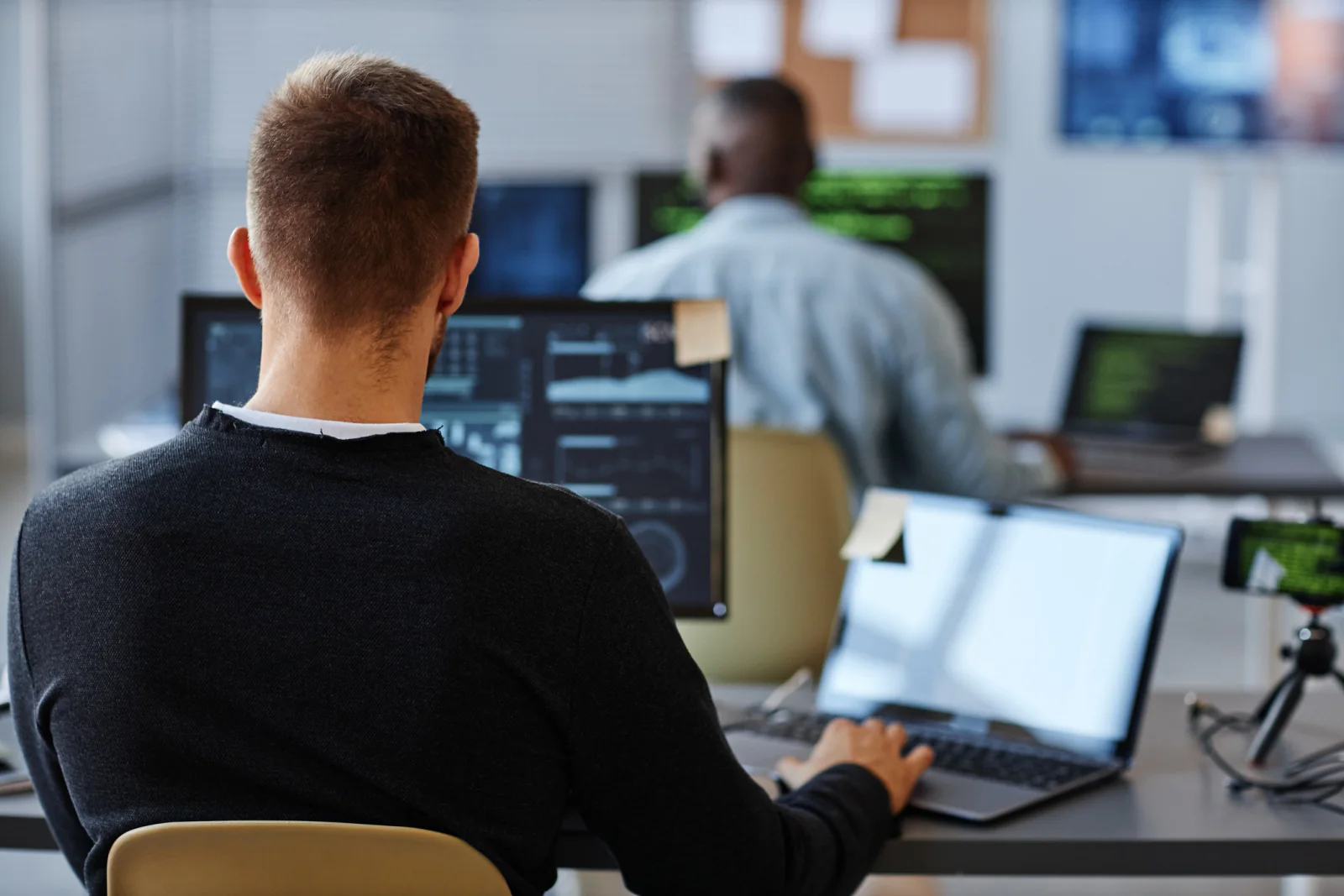 Engineers benchmarking software performance on high-spec laptops and external displays in a controlled validation environment