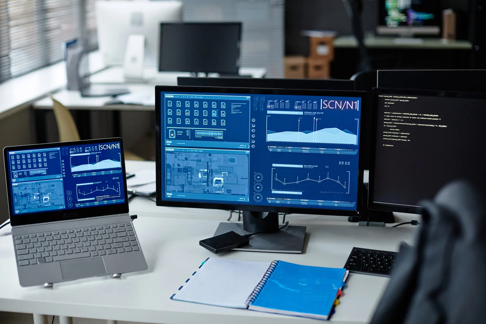 Product demo and stakeholder review room with laptops, large display screens, and software presentation setup
