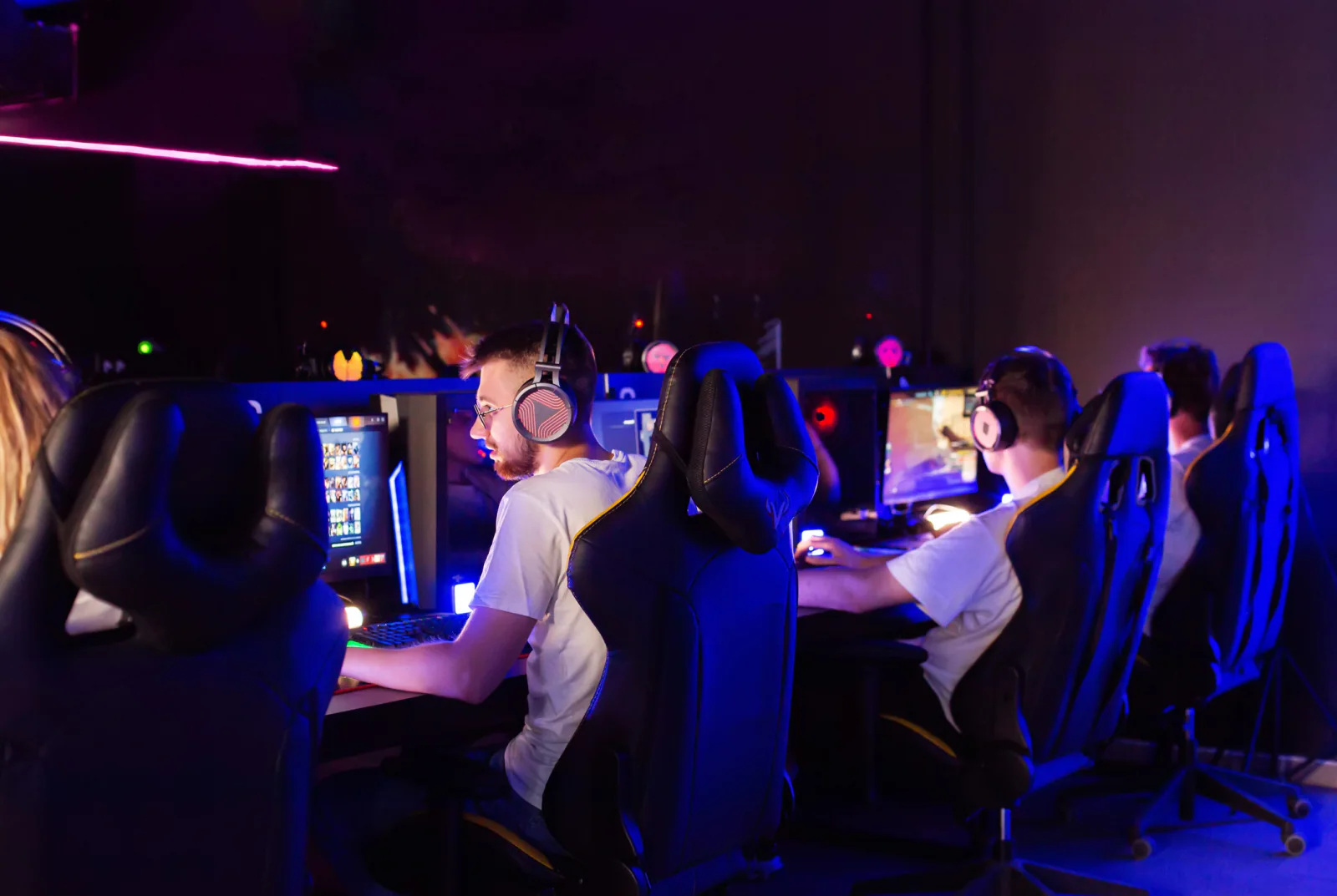 Gaming brand activation area with demo stations, large displays, esports equipment, and attendees interacting with gaming setups