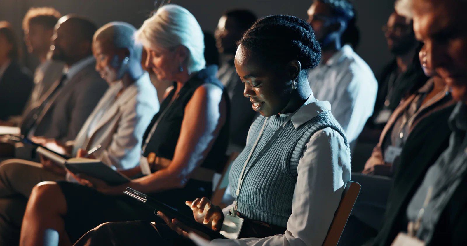 Multiple graduation ceremony support areas with staff coordinating back-to-back event sessions using laptops and tablets