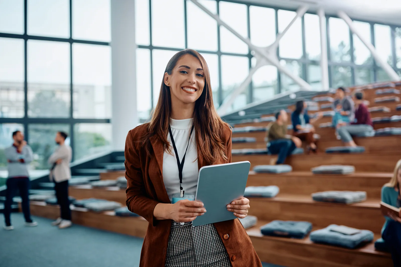Graduation guest services staff using tablets and laptops to assist attendees with seating and ceremony support at a large venue