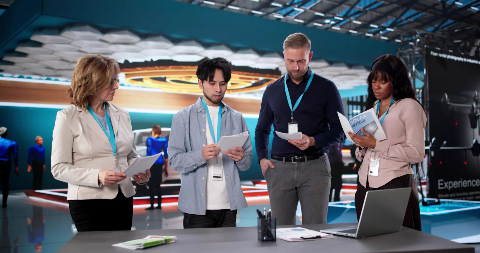 Graduation event staff using laptops and tablets to coordinate ceremony logistics, guest flow, and operations across a venue