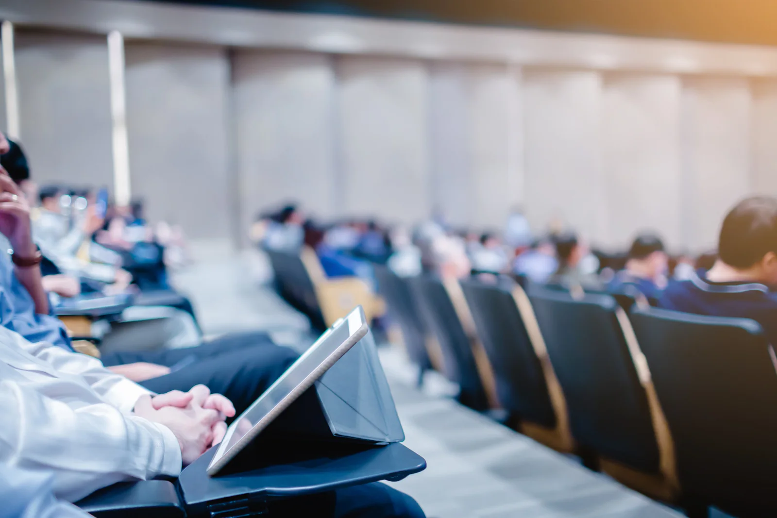 University commencement ceremony with staff using laptops, tablets, and event support technology at a large campus venue