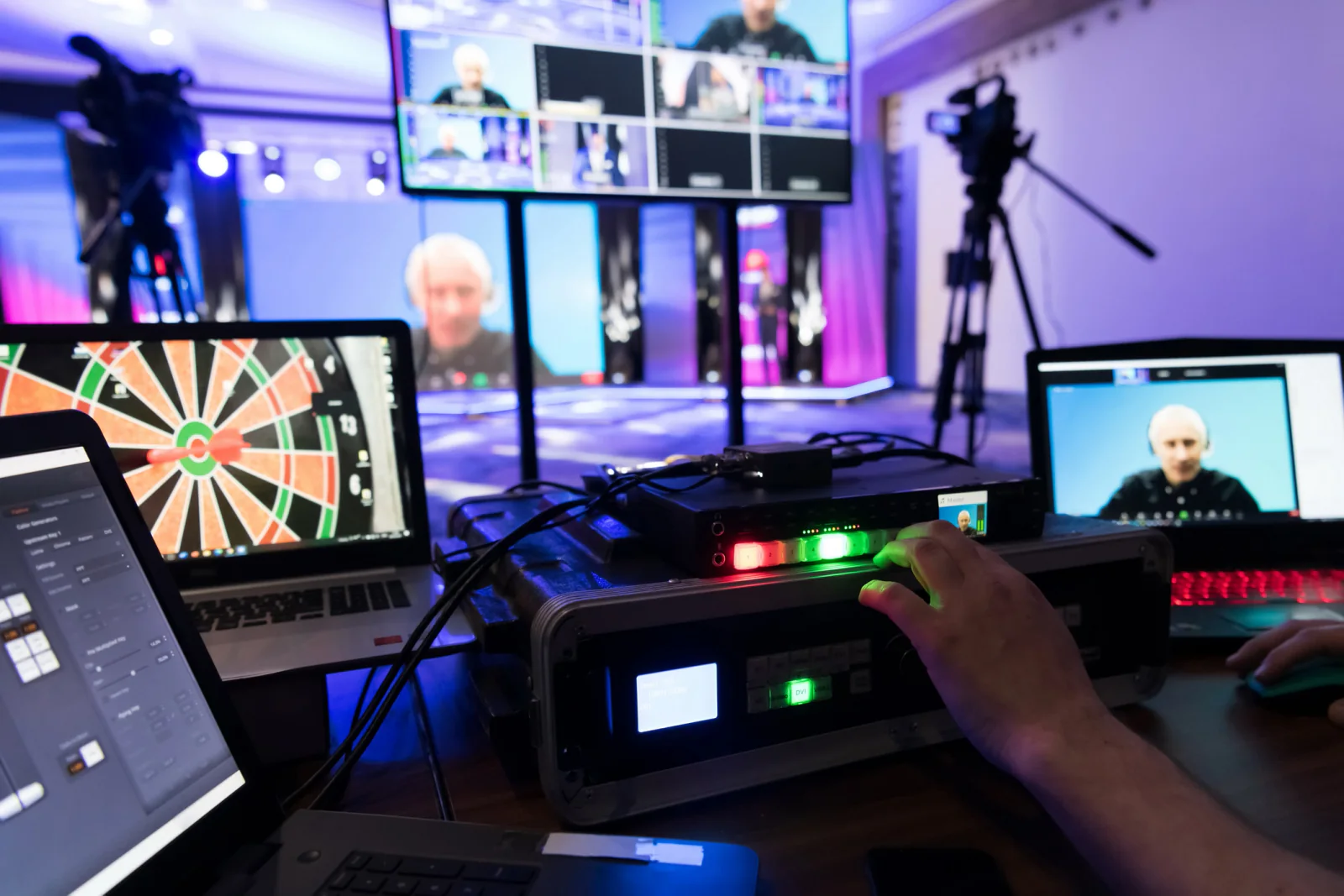 Sporting event operations command center with support displays, laptops, and staff coordinating schedules and venue logistics