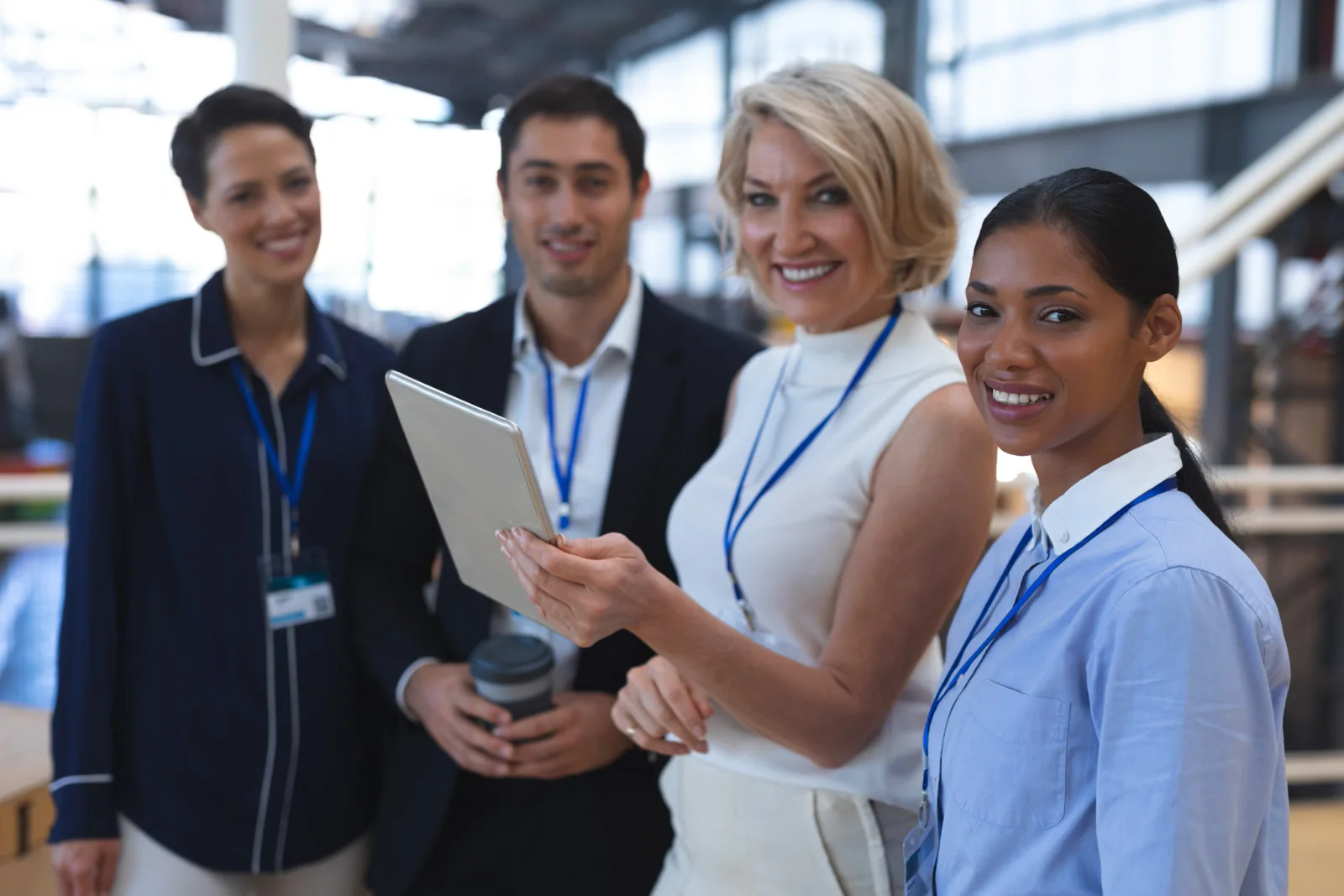 Sporting event credentialing and check-in area with staff using tablets, laptops, badges, and event support technology at a stadium or arena
