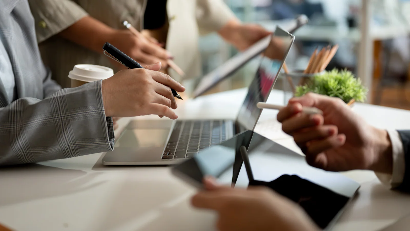 Sporting event credentialing station with staff using laptops, tablets, badges, and event support technology at a stadium or arena