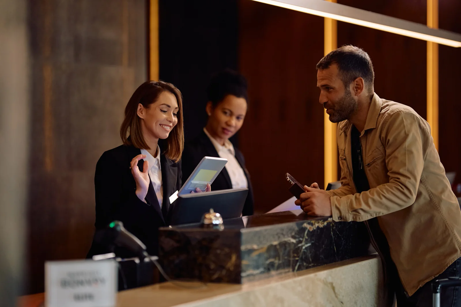 VIP and speaker registration desk with tablets, laptops, attendee lists, and event staff handling special-access check-in