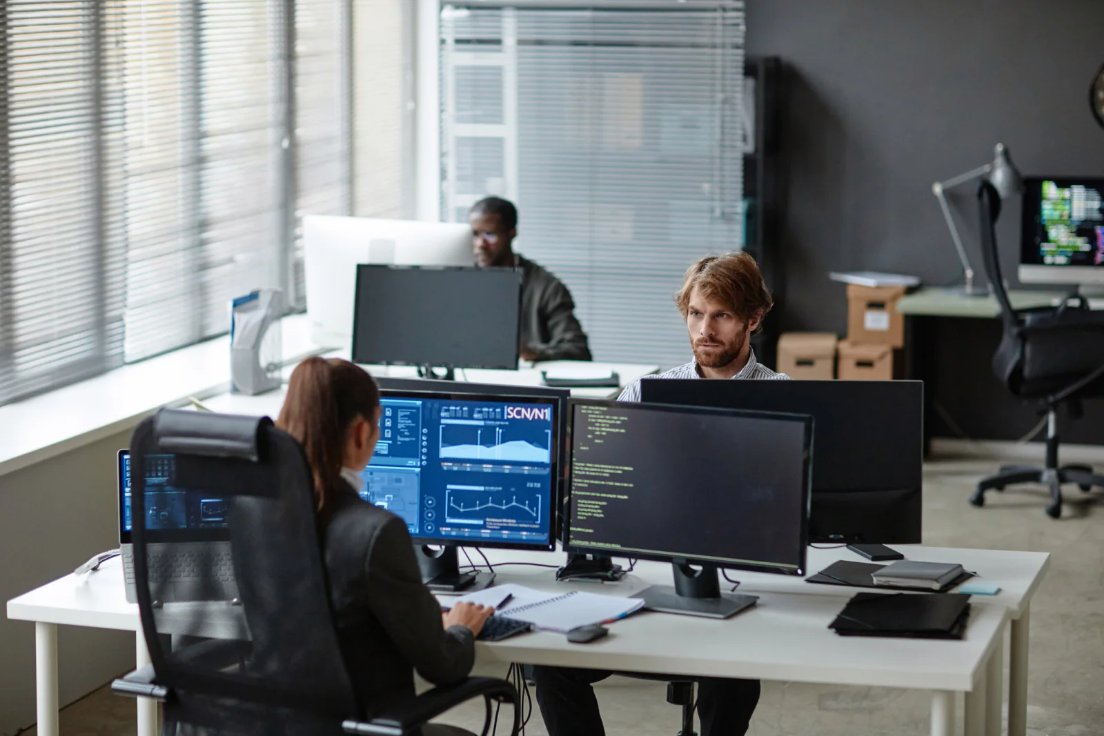 Temporary project room or support center with laptops, monitors, printers, and standardized office equipment for an operations team