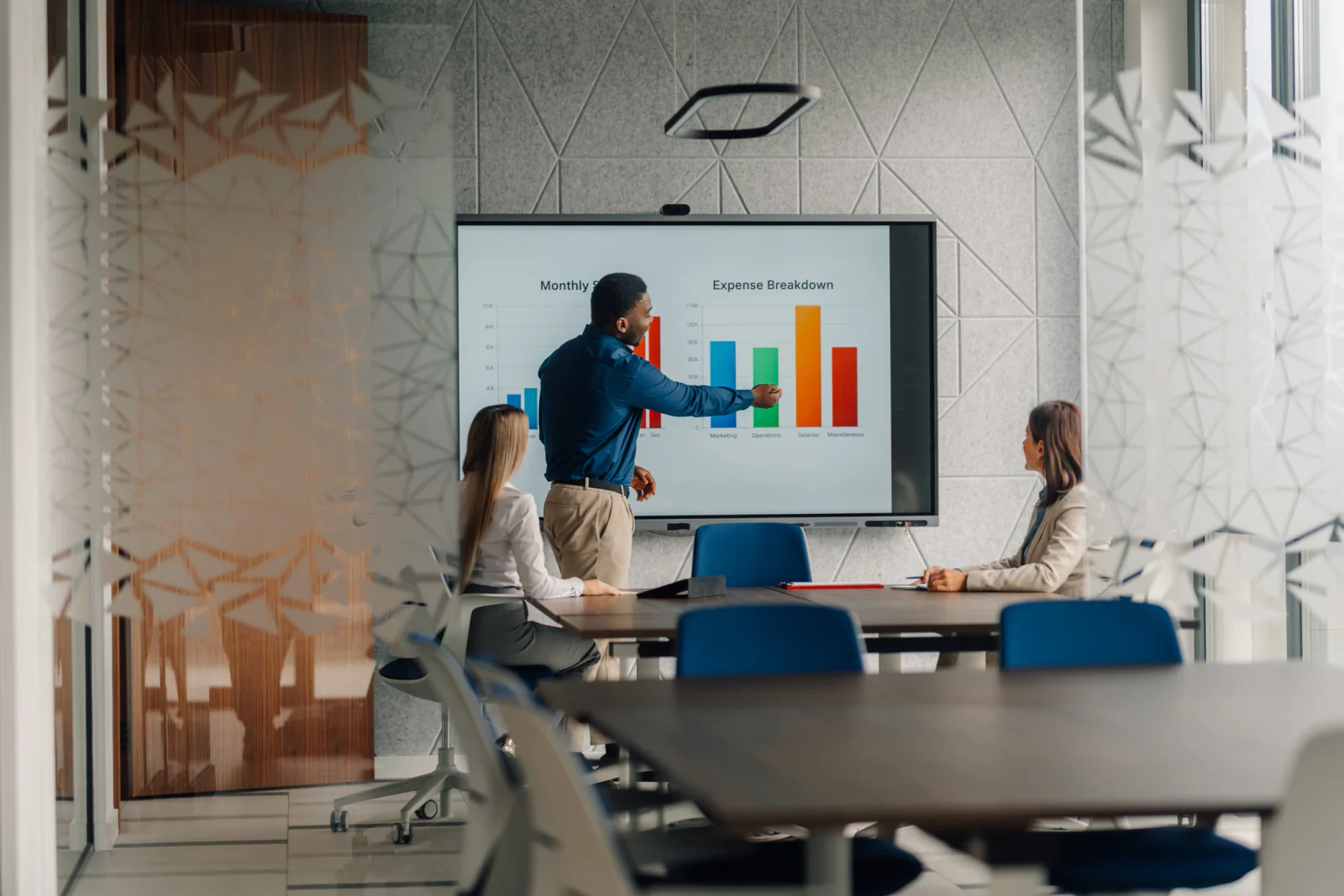 Conference room presentation setup with large display screen, presenter laptop, audience seating, and AV planning for a business meeting