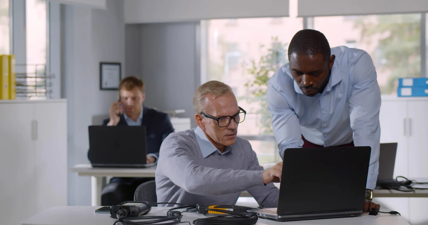 IT support team preparing laptops with required applications, software settings, and workflow-specific configuration before deployment