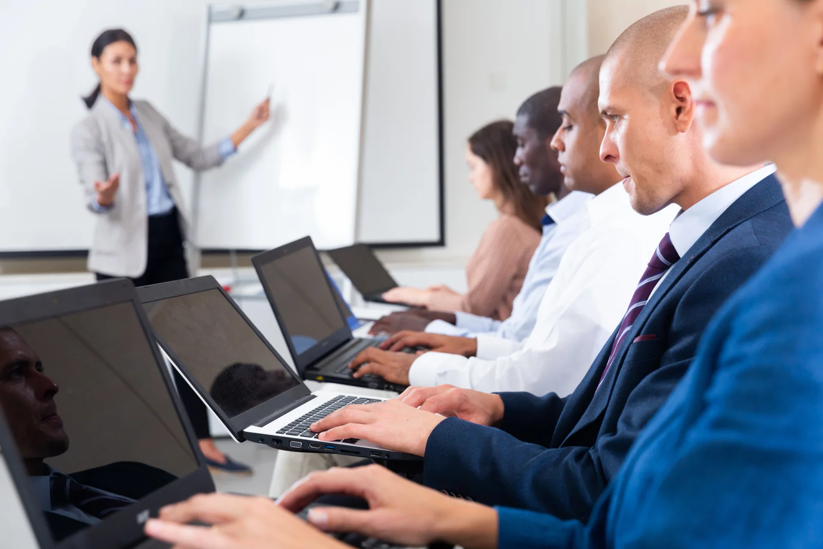 Temporary office team using standardized laptops configured with the same software and settings in a short-term workspace