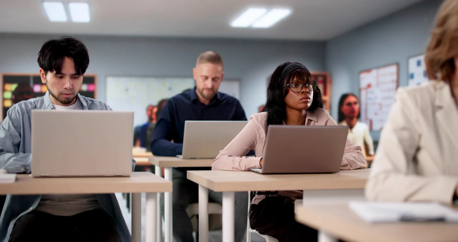 Corporate onboarding classroom with employees using rental laptops during instructor-led training