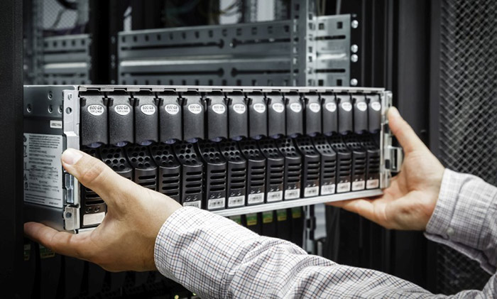 A pair of hands pulling a server out of a rack